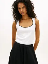 Musculosa blanca de punto de puro algodón, con corte slim, cuello redondo amplio y costuras a contraste en color negro en el cuello y las sisas.