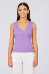 Top largo de punto color lila, ajustado al cuerpo con cuello en V y sisas con detalle ondulado.