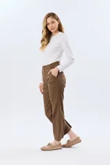 Pantalón de gabardina marrón, de corte recto con pinza en el bajo y detalles de botones en los tobillos.