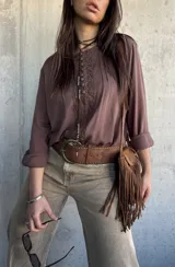 Blusa marrón chocolate de corte oversize, con mangas largas y detalles de encaje y botones forrados en el frente.