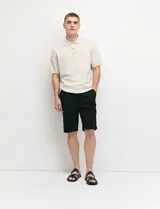 Bermuda chino de corte recto, color verde militar, confeccionada en algodón con elastano. Cuenta con bolsillos laterales de estilo italiano y bolsillos traseros con botón.