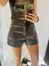 Short de cuero sintético color gris oscuro, corte oversize, con elástico en la cintura, cierre y botón.