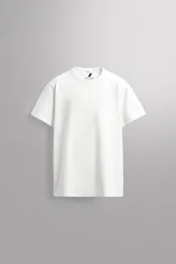 Camiseta de corte relajado confeccionada en tejido compacto de algodón pesado, con cuello redondo y manga corta.