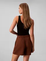 Short cargo de talle alto confeccionado en una mezcla de lino y algodón. Presenta cierre frontal con botón y cremallera, bolsillos laterales con solapa y botones decorativos, ofreciendo un estilo utilitario y relajado.