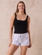 Conjunto de pijama de dos piezas marca René Rofé, compuesto por un top blanco de breteles finos y un short gris con rayas horizontales blancas, cintura elastizada y cordón de ajuste.