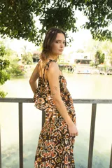 Falda larga de algodón con estampado étnico en tonos marrones, naranjas y blancos. Presenta un corte irregular y cierre invisible lateral.