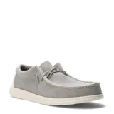 Zapatos tipo slip-on de tela color beige, con cordones elásticos decorativos, bordes deshilachados y suela blanca de goma.
