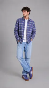 Camisa de manga larga con estampado de cuadros en tonos azules y líneas finas amarillas, con cierre frontal de botones y cuello clásico.