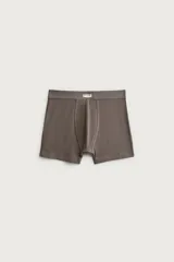 Pack de tres calzoncillos tipo bóxer de algodón elástico, en tonos gris claro, gris topo y marrón oscuro, con cintura elástica y pequeña etiqueta frontal con inscripción.