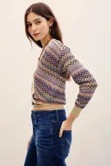 Cardigan cruzado de punto con estampado en zigzag en tonos lila, beige y negro, escote en V cruzado, mangas largas y lazo para atar en la cintura.