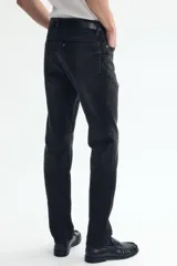 Jean de cinco bolsillos en denim de algodón con ligero stretch, corte ajustado en cintura, muslos y bajo, con piernas rectas y cintura estándar.