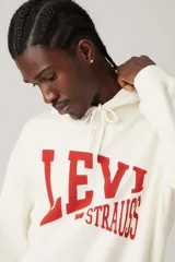 Buzo hoodie color crema con logo Levi's estampado en rojo en el frente.