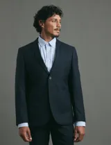 Saco sport de corte clásico, con cuello de solapa, cierre frontal de dos botones y bolsillos de ribete laterales.