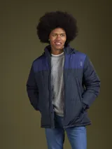 Campera puffer azul marino con canesú azul más claro en la parte superior y capucha. Cierre frontal con cremallera y bolsillos laterales.