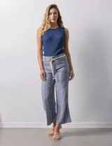 Pantalón de lino a rayas verticales en tonos azul, beige y blanco, con corte wide leg, pretina con pasadores, cierre y botón. Incluye cinturón de soga con hebilla redonda.