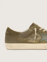 Zapatillas Golden Goose Super-Star de cuero vacuno en tono verde militar, con efecto envejecido, estrella lateral en cuero más oscuro y cordones de algodón en color crudo.