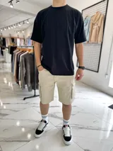 Bermuda cargo de jean color beige, con bolsillos laterales con solapa en las piernas y corte holgado.