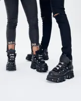Borcego negro de cuero con plataforma track y detalles metálicos. Ajuste con cordones y hebillas.