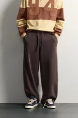 Pantalón jogger relaxed fit de color marrón con efecto lavado, cintura elástica ajustable con cordón y bolsillos laterales.