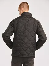 Campera acolchada de color negro con diseño de rombos, cierre frontal completo y cuello alto. Presenta el logo de la marca Caterpillar en un parche de silicona sobre el pecho.