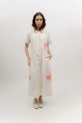 Vestido midi camisero negro con estampado floral, cuello camisero, manga corta y cierre frontal con botones.