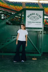 Pantalón Oxford negro de lycra gruesa, con corte acampanado, tiro medio y tajos laterales.