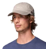 Gorra Columbia Provisions Ball de color gris claro, confeccionada en algodón, con diseño clásico de seis paneles, visera curva y cierre posterior ajustable. Cuenta con el logotipo de la marca bordado en el frente y un pequeño detalle bordado en el lateral.