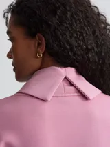 Buzo rosa de cuello alto con cordón ajustable en la cintura.