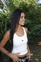 Musculosa de punto acanalado en color blanco, con diseño ajustado al cuerpo y bordado pequeño de un caballo en el centro del pecho.
