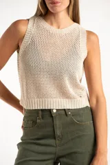 Chaleco tejido sin mangas de calce al cuerpo, con cuello redondo y diseño de punto abierto. Presenta terminaciones acanaladas en cuello, sisas y ruedo.
