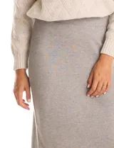 Falda midi de tejido con lurex, color beige, con pretina ancha elastizada y tajo en el ruedo trasero.