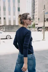 Chaqueta de punto color azul marino, con cuello redondo, manga larga y cierre frontal con botones. Los acabados son en rib a tono.