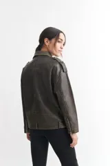Campera tipo biker de cuero sintético color gris oscuro con efecto desgastado, cierre cruzado con cremallera, cuello con solapas y múltiples bolsillos con cremallera.
