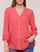 Blusa celeste de silueta suelta y textura liviana, con escote en V, cuello mao y cierre frontal de botones. Cuenta con alforzas verticales en el pecho y mangas tres cuartos con puños elastizados y detalle de galón calado.