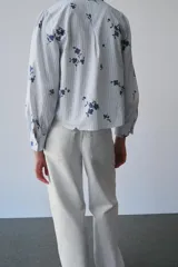 Jeans de mezclilla en color negro gastado, tiro bajo, corte de pernera recta y diseño clásico de cinco bolsillos con cierre frontal de cremallera y botón metálico.