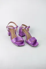 Sandalias de fiesta metalizadas color celeste, con taco cuadrado de 4 cm, tiras delanteras acolchadas y tira ajustable al tobillo con hebilla dorada.