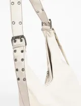 Cartera hobo negra de cuero sintético con costuras blancas decorativas y múltiples cierres diagonales en el frente. Tiene una correa de hombro ajustable.