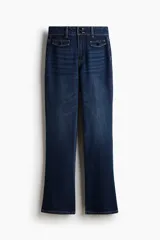 Jean de denim azul oscuro con leve stretch, corte de tiro alto, ajustado en la parte superior y acampanado desde la rodilla hacia el bajo. Presenta doble botón en la cintura y bolsillos delanteros simulados con solapa y botón.