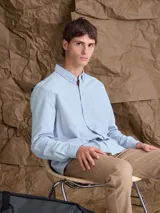 Camisa de corte clásico confeccionada en tejido Oxford de algodón, con cuello abotonado, bolsillo frontal y cierre de botones.