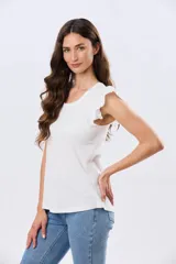 Remera de algodón color beige, de manga corta con volados de broderie, escote redondo y cuerpo liso.