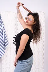 Blusa negra con escote corazón, mangas cortas abullonadas y cierre frontal con múltiples lazos para atar.