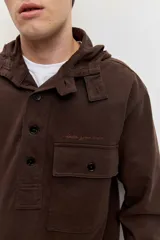 Buzo de friza de algodón marrón con capucha, cuello tipo polo con botones y un bolsillo frontal con solapa en el pecho.