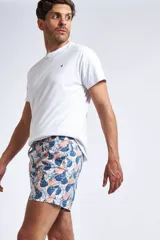 Short de baño con estampado de ondas en tonos azules, cintura elástica con cordón ajustable, bolsillos laterales y bolsillo trasero. Incluye suspensor interno y logo bordado.