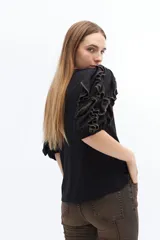 Remera color beige con mangas cortas y volados con borde naranja.