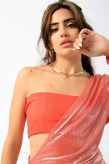 Vestido largo de fiesta color salmón con acabado metalizado, diseño strapless y manga larga caída con detalle drapeado.