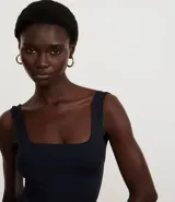 Vestido largo tipo midi de corte ajustado, confeccionado en poliamida con elastano. Presenta escote cuadrado, breteles anchos y una abertura lateral en el ruedo.