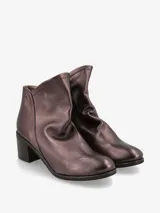 Botín plateado de cuero italiano con diseño moderno y silueta estilizada. Su taco ancho brinda estabilidad y comodidad, mientras que el corte limpio realza la elegancia del modelo.