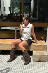 Botas texanas de gamuza color marrón con diseño de flecos largos en toda la caña, taco cuadrado y punta redondeada.