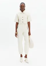 Camisa corta color blanco con diseño acolchado y botones marrones.