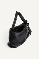 Bolso tipo shopper de hombro confeccionado en piel de alta calidad, con diseño minimalista y cierre principal mediante cremallera. Cuenta con un bolsillo interior con cierre y asa ajustable.